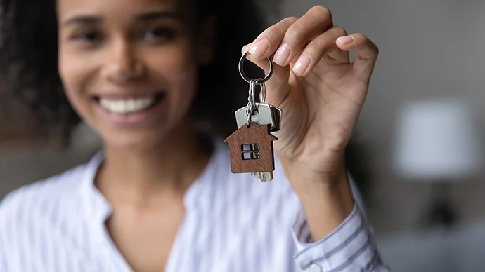 Woman holding keychain with a house on it
